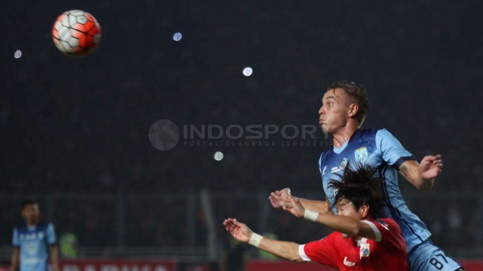 Pemain Persela Lamongan, Kristian Adelmund (atas) berduel udara dengan Pemain Persija Jakarta,Soon Hak Hong (bawah).